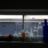 She found these decades-old bottles under her home. Now they adorn her shower window along with spiderwebs